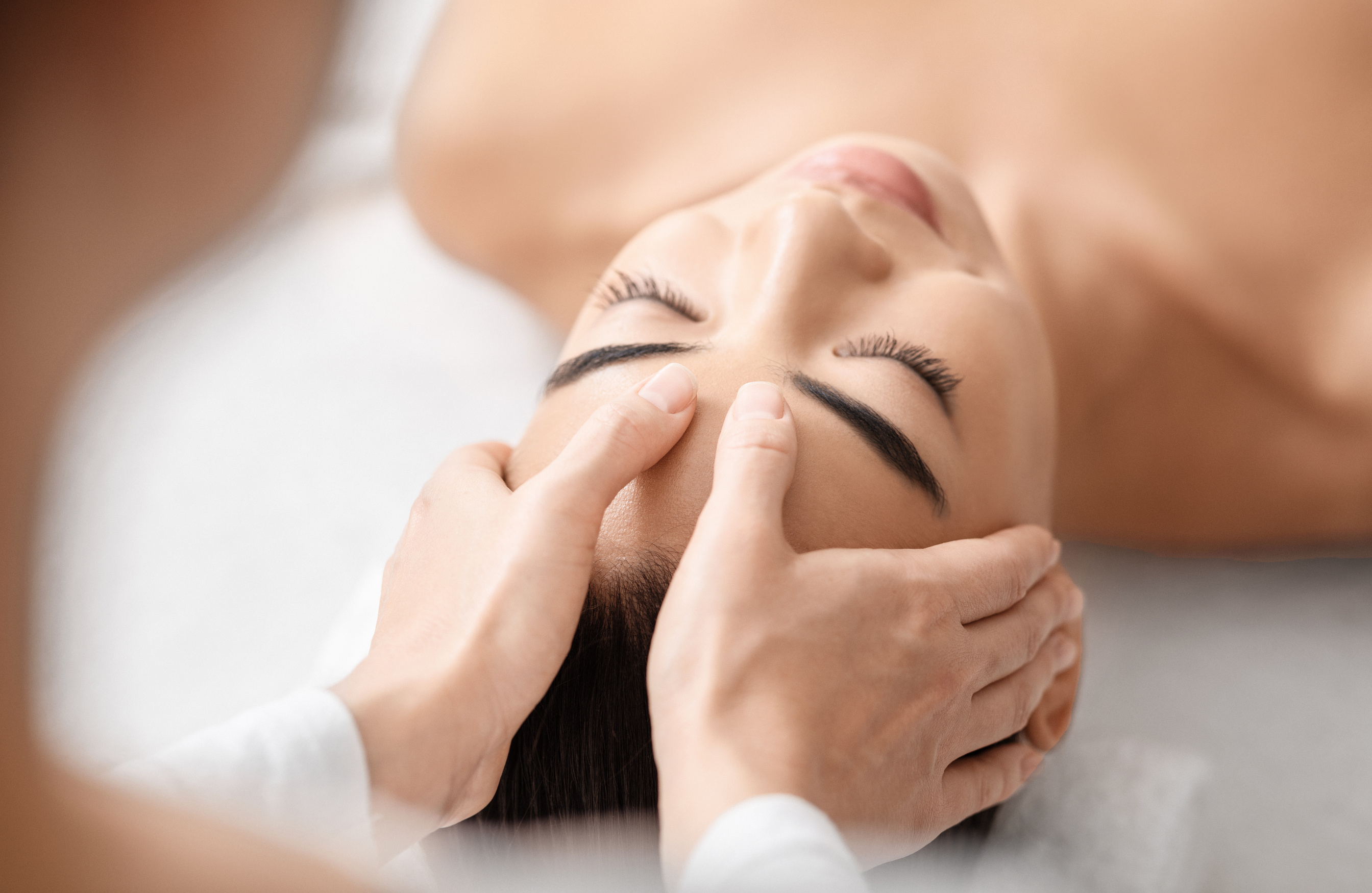 Young attractive korean woman getting acupressure massage treatment in spa salon